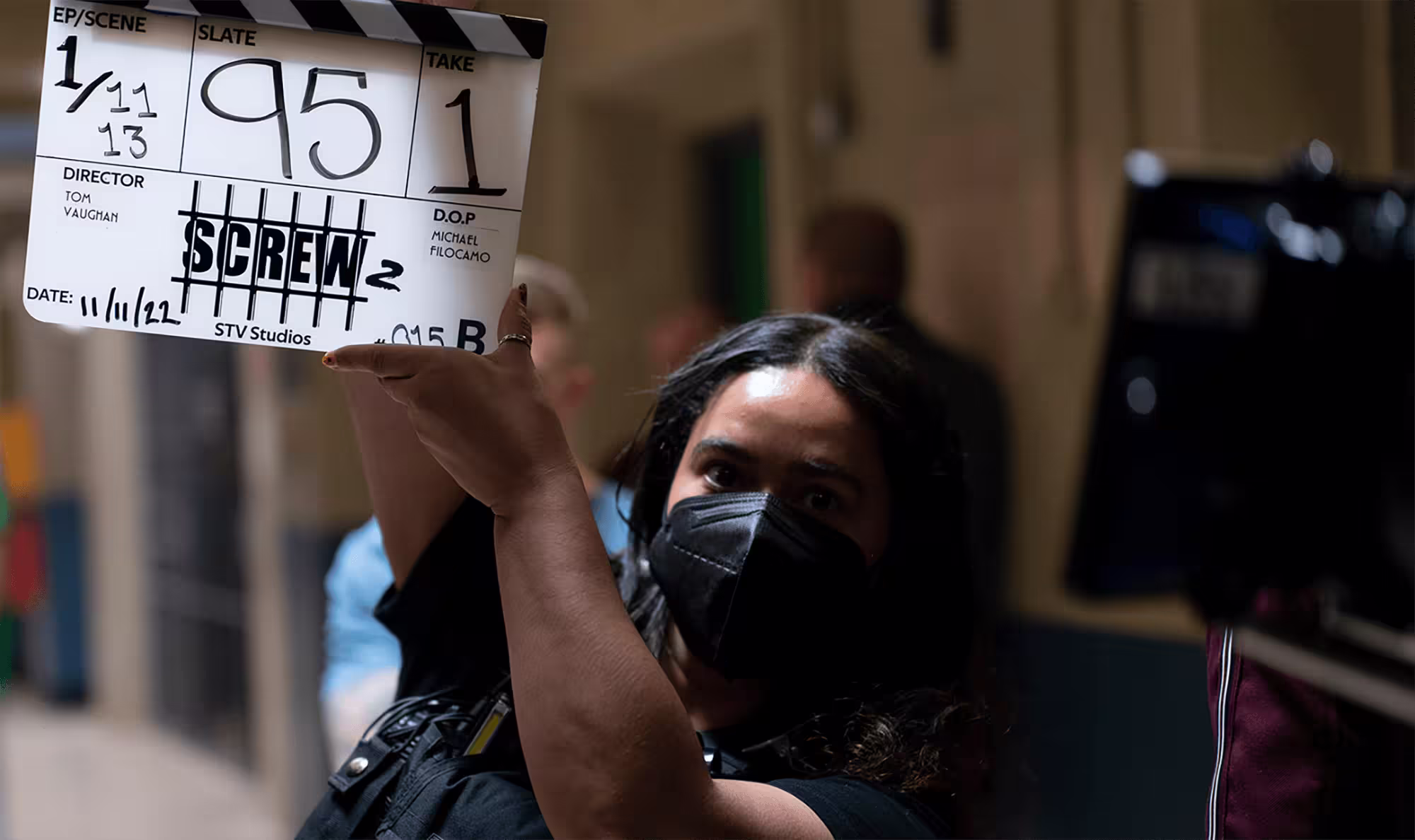 Production assistant holding a clapperboard.